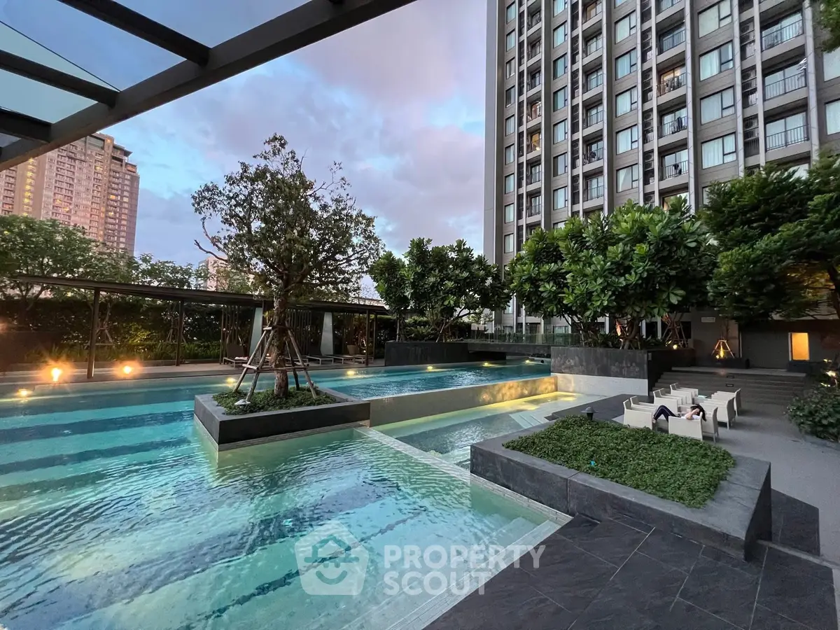 Luxurious apartment complex with stunning outdoor pool and lush greenery, perfect for relaxation and leisure.