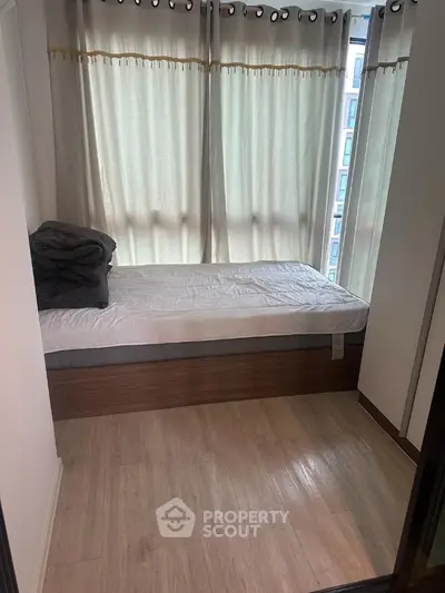Cozy bedroom with single bed and natural light from large windows