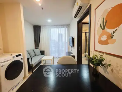 Modern living room with washing machine and stylish decor in a cozy apartment.