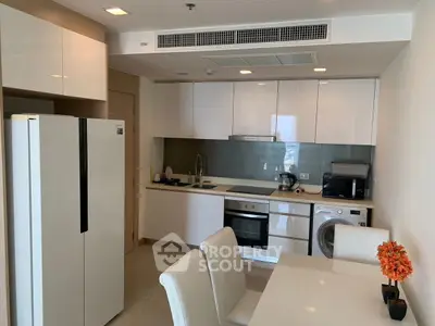 Modern kitchen with sleek appliances and dining area in a stylish apartment.