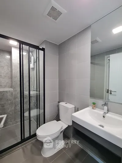 Modern bathroom with sleek shower and elegant fixtures in contemporary apartment.