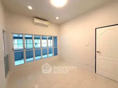 Bright and spacious room with large windows and air conditioning, perfect for modern living.