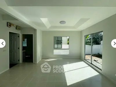Spacious and bright living room with large windows and modern ceiling design