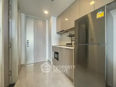 Modern kitchen with sleek cabinetry and stainless steel appliances in a stylish apartment.