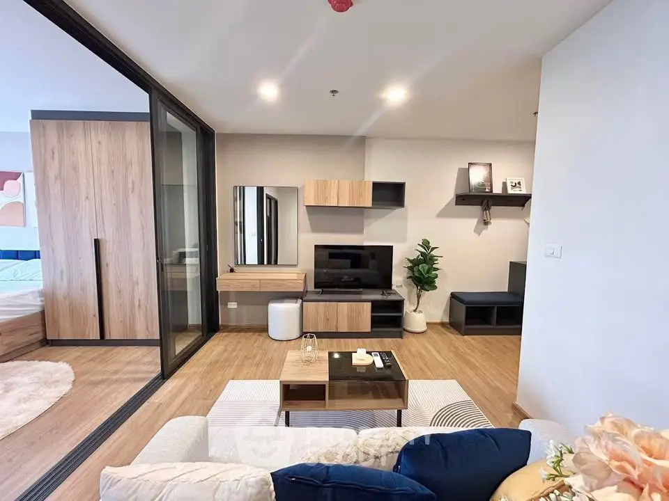 Modern living room with stylish decor and open layout, featuring a cozy seating area and entertainment center.