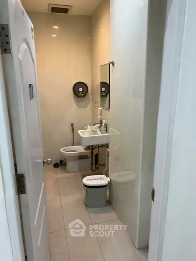 Compact bathroom with modern fixtures and neutral tiles, ideal for small spaces.