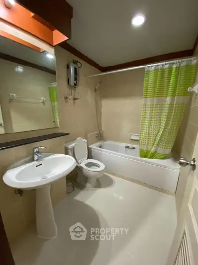 Modern bathroom with bathtub, shower, and stylish green accents in a cozy apartment.