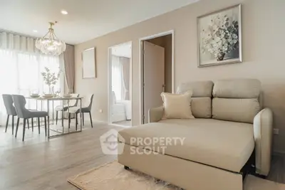 Elegant living room with modern decor and dining area, featuring a cozy sofa and stylish chandelier.