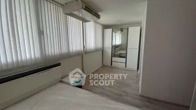 Spacious bedroom with modern wardrobe and large windows