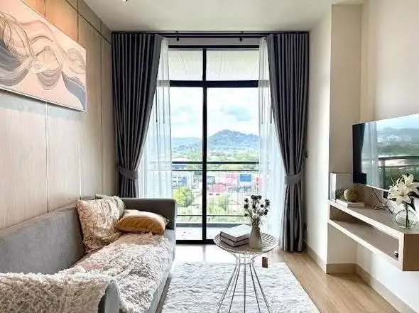 Modern living room with large window and scenic view, featuring cozy sofa and stylish decor.