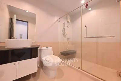 Modern bathroom with glass shower enclosure and sleek fixtures