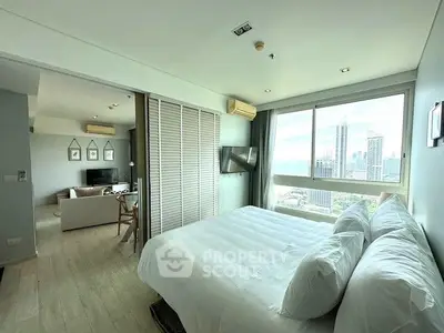 Spacious bedroom with city view and adjoining living room in modern apartment.