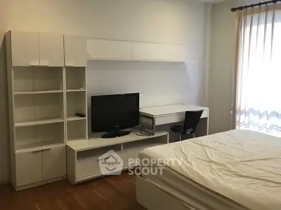 Modern bedroom with sleek white furniture and natural light