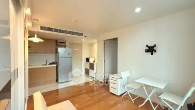 Modern open-layout kitchen and living area with sleek appliances and stylish furniture.