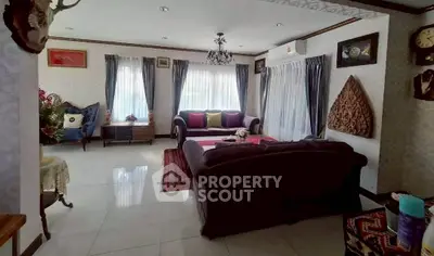 Elegant living room with classic decor, plush sofas, and natural light from large windows.