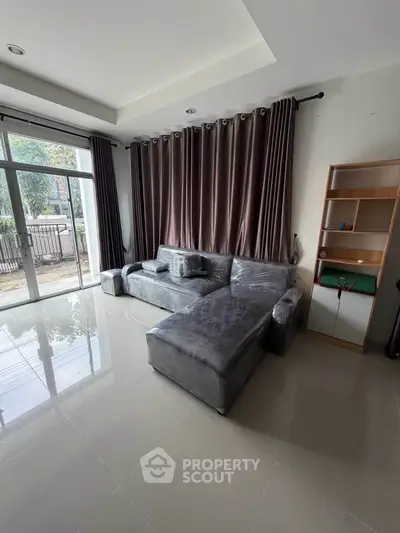 Spacious living room with modern gray sofa and large windows for natural light