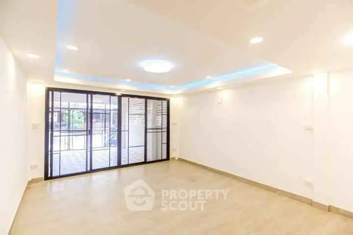 Spacious and bright living room with modern lighting and large sliding doors.