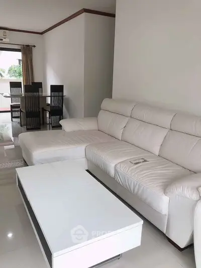 Spacious living room with modern white sectional sofa and sleek coffee table