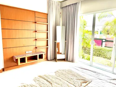 Bright living room with wooden shelves and large window overlooking garden