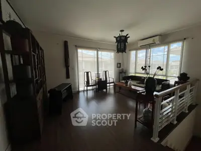 Spacious living room with large windows and elegant decor, featuring a serene view.