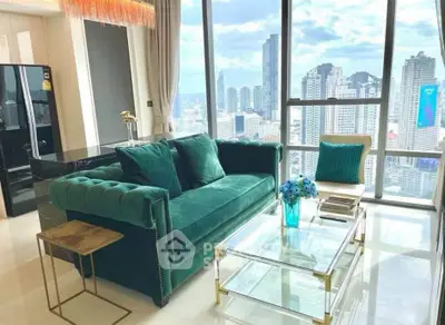 Luxurious living room with stunning city view, featuring elegant green sofa and modern glass coffee table.