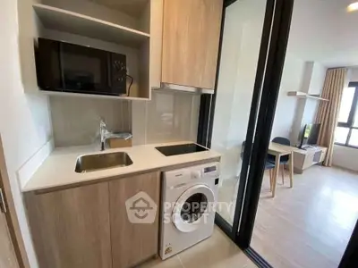 Modern compact kitchen with washing machine and open layout to living area