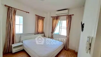 Bright bedroom with large windows and air conditioning in modern apartment