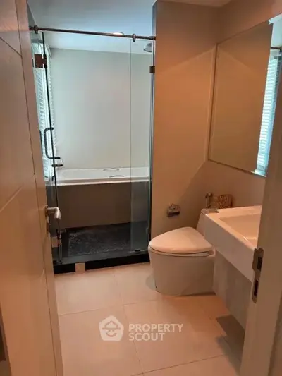 Modern bathroom with glass shower and sleek fixtures in a contemporary apartment.