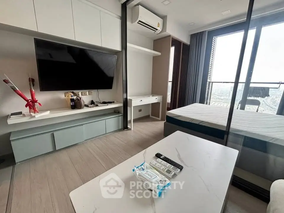 Modern living room with sleek TV setup and balcony view in a stylish apartment