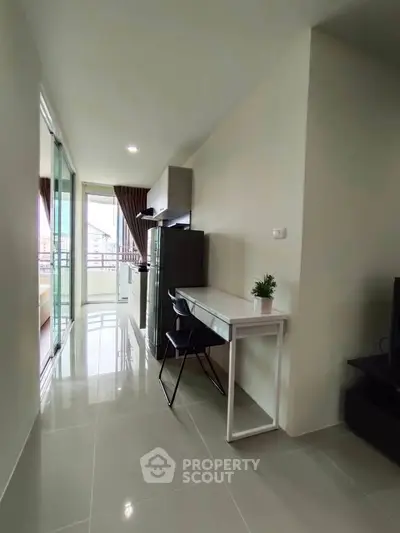 Modern apartment interior with sleek design and balcony view, featuring a study area and contemporary furnishings.