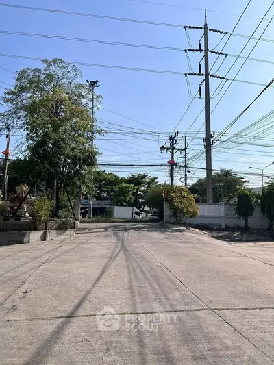 Spacious outdoor area with clear sky and utility poles, ideal for development.