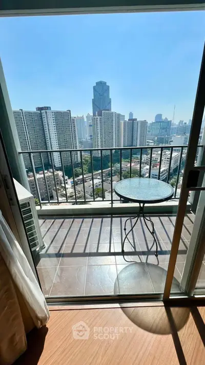 Stunning city view from a modern apartment balcony with glass table, perfect for urban living.