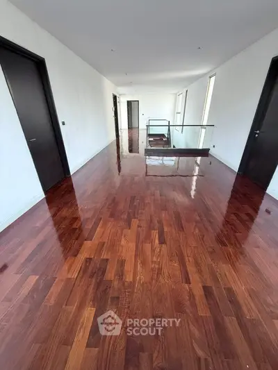 Spacious hallway with polished wooden floors and modern design in a luxury apartment.