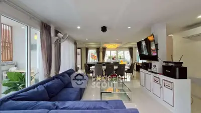 Spacious modern living room with blue sectional sofa and elegant dining area