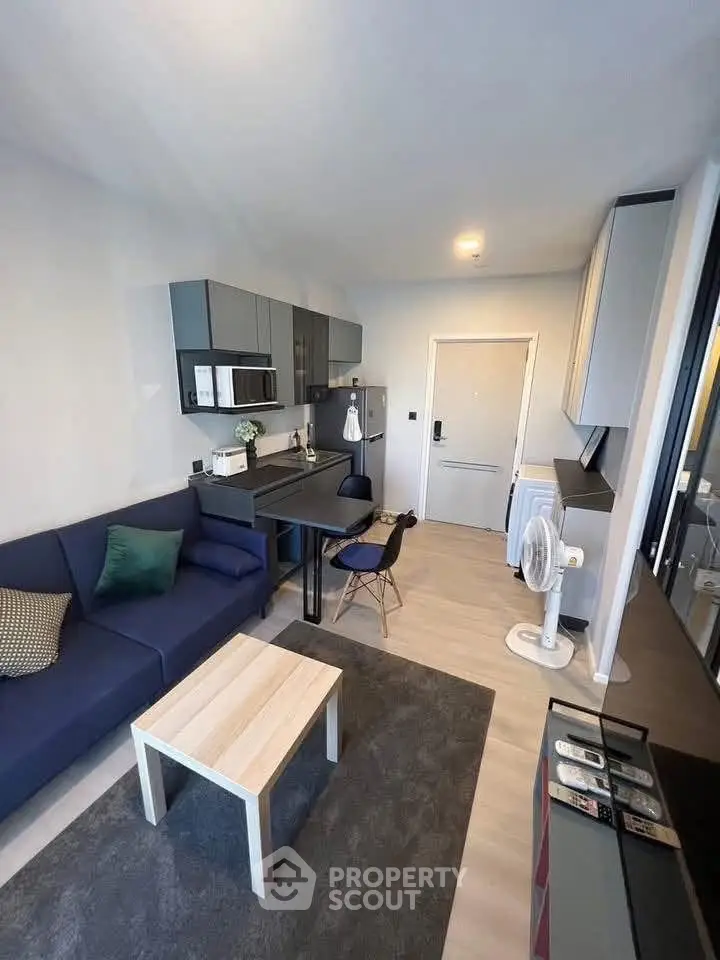 Modern compact living room with open kitchen layout and stylish furnishings