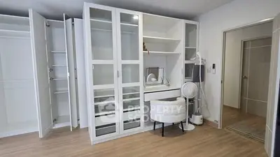Spacious bedroom with modern white wardrobe and vanity set