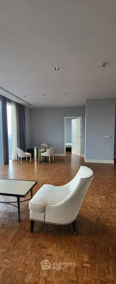Spacious living room with parquet flooring and modern furniture, offering a serene ambiance.