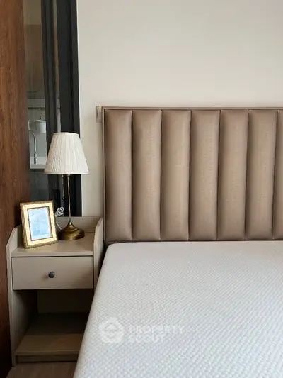 Elegant bedroom with modern headboard and stylish bedside lamp