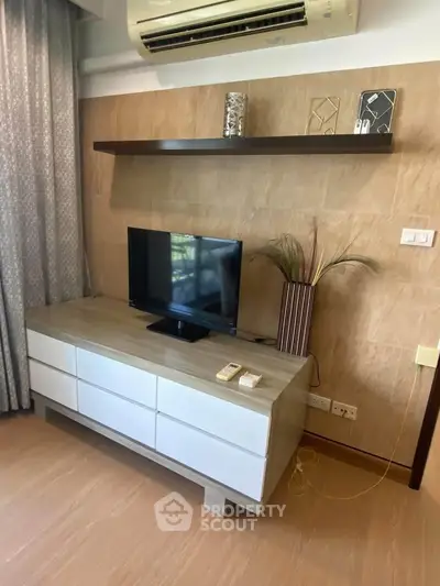 Modern living room with stylish TV stand and air conditioning, perfect for cozy relaxation.