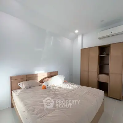 Spacious bedroom with modern design and ample natural light, featuring a cozy bed and sleek storage solutions.