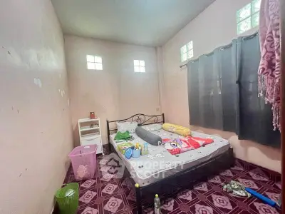 Cozy bedroom with natural light and simple decor, ideal for comfortable living.