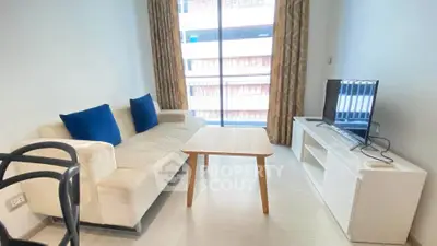 Modern living room with cozy sofa, TV, and large window in a stylish apartment.