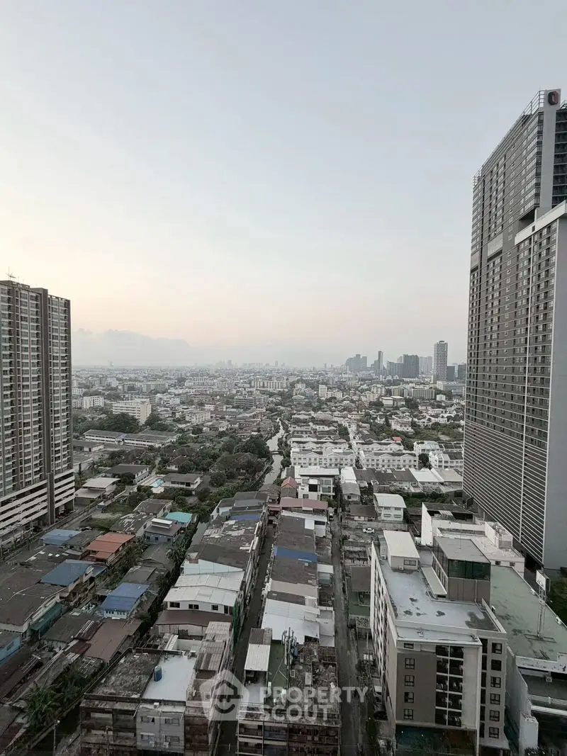Stunning cityscape view from high-rise building showcasing urban skyline and residential areas.