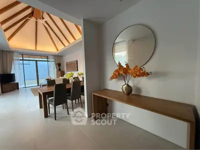 Spacious modern living room with vaulted ceiling and elegant dining area