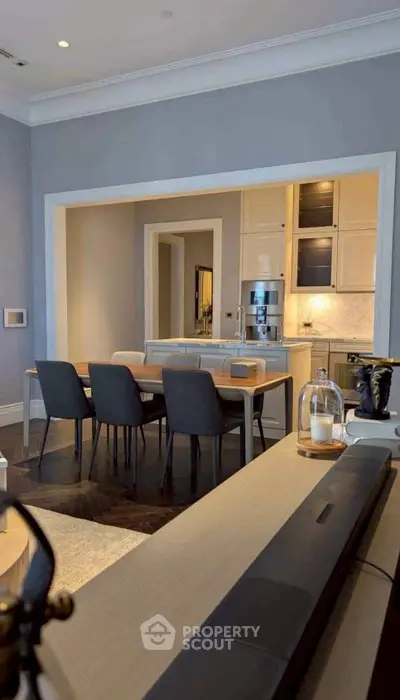 Elegant dining area with modern furniture and open kitchen layout in a stylish apartment.
