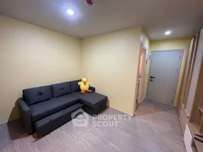 Cozy living room with modern gray sofa and plush duck toy, perfect for relaxation.