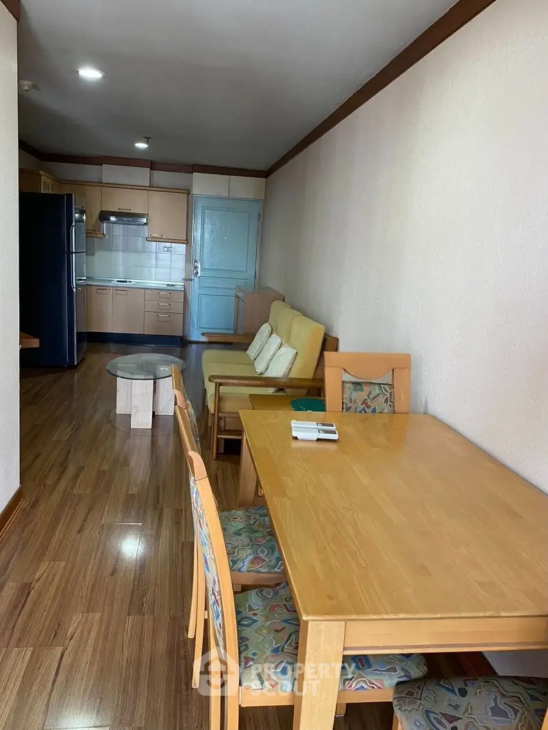 Spacious open-plan living and dining area with wooden flooring and modern kitchen.