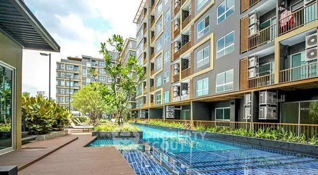 Modern apartment complex with pool and lush landscaping