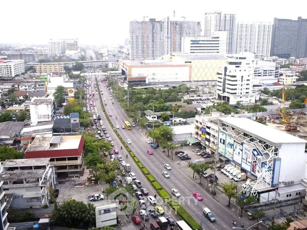 Aerial view of bustling cityscape with high-rise buildings and busy roads.