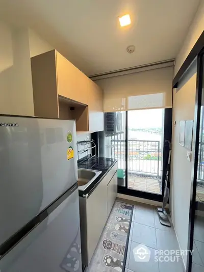 Modern kitchen with balcony view, featuring sleek appliances and stylish cabinetry.